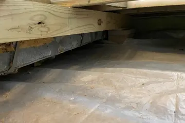 Crawlspace floor insulation and vapor barrier installation under wood framing