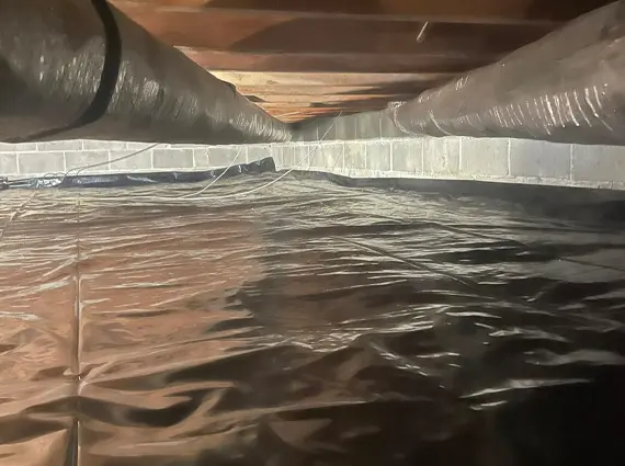 Crawl space encapsulation with black vapor barrier protecting foundation in Fulton County Kentucky home